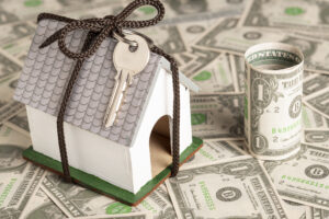 Wrapped house with keys and money in the background