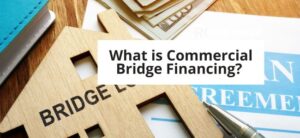 Background of image shows wood house that says bridge and legal papers. Written in a box is "What is commercial bridge financing?"