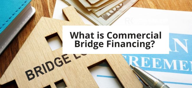 Background of image shows wood house that says bridge and legal papers. Written in a box is "What is commercial bridge financing?"