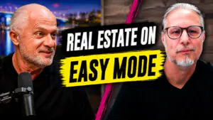 Two men with gray beards speak into a microphone, with a bold banner reading 'REAL ESTATE ON EASY MODE' between them.